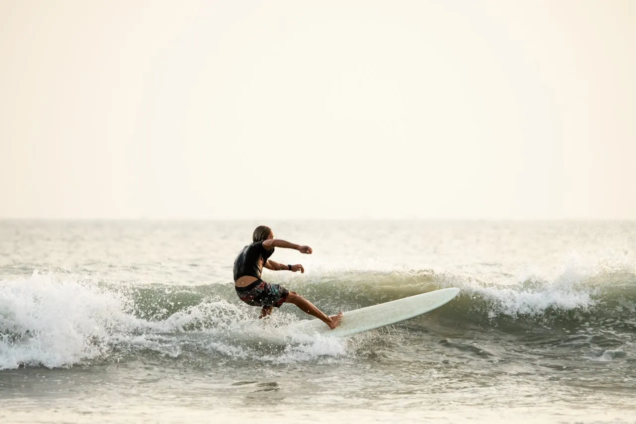 Unrecognizable man surfing on surfboard in ocean Sri Lanka